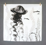 Loose black and white illustrated Jellyfish with long floaty tendrils on a square napkin, hanging on a line with small wooden pegs